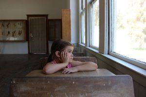 Niña sentada en un pupitre de escuela
